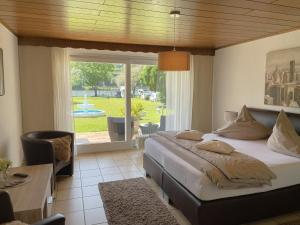 a bedroom with a large bed and a large window at Ferienwohnungen Lohmann in Bullay