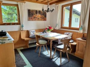 a dining room with a table and chairs and windows at Stille Auszeit in Zams