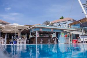a swimming pool with a bar next to a building at Caybeach Meloneras in Meloneras