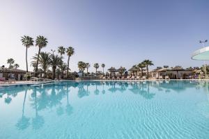 a large swimming pool with palm trees in a resort at Caybeach Princess in Maspalomas