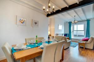 a dining room and living room with a table and chairs at St Judes in The Mumbles