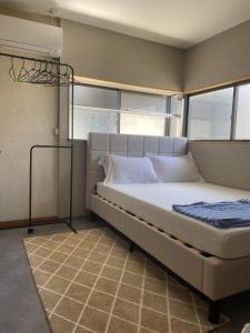 um quarto com uma cama em um quarto com janelas em ラッコ ゲストハウス 海獭青旅 Sea Otter Guest House em Shimoda