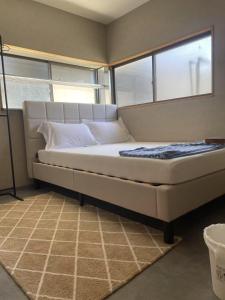 uma cama grande num quarto com janelas em ラッコ ゲストハウス 海獭青旅 Sea Otter Guest House em Shimoda