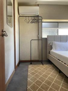 um pequeno quarto com uma cama e uma porta com janela em ラッコ ゲストハウス 海獭青旅 Sea Otter Guest House em Shimoda