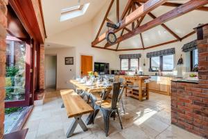 una cucina e una sala da pranzo con tavolo e sedie di Driftwood House a Parkmill