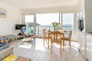 a living room with a table and chairs and a balcony at 9_306B Redcliffe Apartments, Caswell Bay in Bishopston