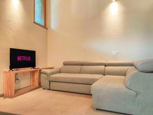 a living room with a couch and a tv at ai Parlenti 25 - openspace in Tirano