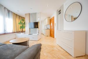a living room with a couch and a mirror at Apartman Simonovic in Vrnjačka Banja