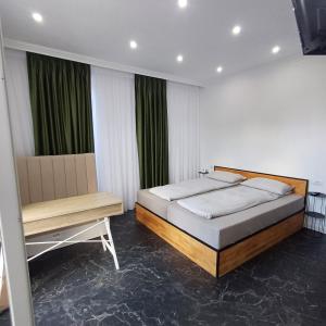 a bedroom with a bed and a bench in it at Casa Noa in Marginea