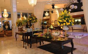 um lobby com duas mesas com flores em Fiesta Bahiana Club Hotel em Irecê