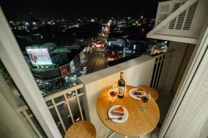 ダバオシティにあるCozy 1BR with 3 Balconies across Roxas Night Marketのバルコニーにテーブルとワイン1本