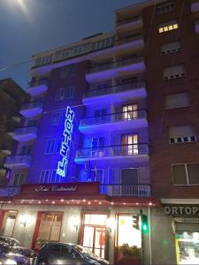 a building with a blue lit up sign on it at Hotel Continental in Turin