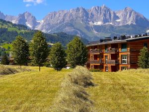 a building on a hill with mountains in the background at Kitzbühel Residences in Kitzbühel