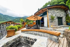 a house with a deck with an umbrella at Oria Hotel Boutique in Çamlıhemşin
