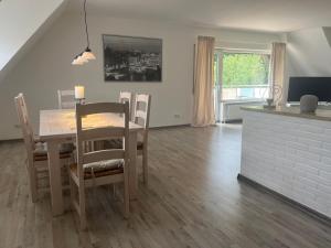 a kitchen and dining room with a table and chairs at Ferienwohnung Am Gladeberg in Hardegsen