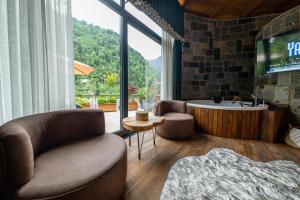 a living room with a large window and a tub at Oria Hotel Boutique in Çamlıhemşin