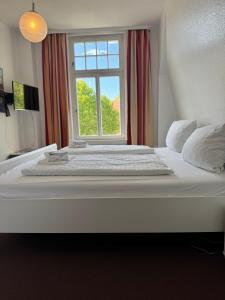 a large white bed in a room with a window at Greetsieler Börse in Greetsiel