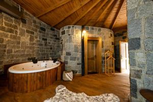 a large bathroom with a tub in a stone wall at Oria Hotel Boutique in Çamlıhemşin +62 photos