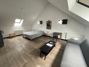 a attic room with a bed and a table at La Grange De Salomé in Salomé
