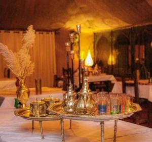 a table with a tray with glasses on it at lion Desert luxury Camp in Merzouga