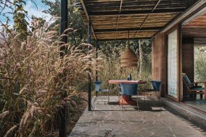 a patio with a table and chairs under a roof at Tipai Wildlife Luxuries in Pahāpal