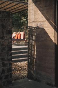 a bench with orange pillows sitting on it at Tipai Wildlife Luxuries in Pahāpal