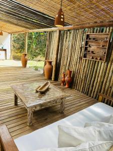 a wooden deck with a table and some pots at Pousada Amor de Casa in Trancoso