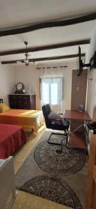 a bedroom with a desk and a bed and a chair at La Casa de la Abuela in Pinos Genil
