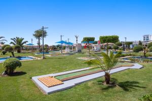 a park with a palm tree in the grass at Pickalbatros White Beach Resort - Hurghada in Hurghada