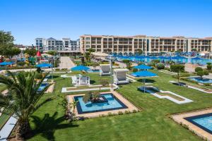 an aerial view of a resort pool with blue umbrellas at Pickalbatros White Beach Resort - Hurghada in Hurghada