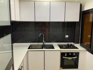 Una cocina blanca con fregadero y estufa. en Appartement de rêve, en Dakar 10 fotos más