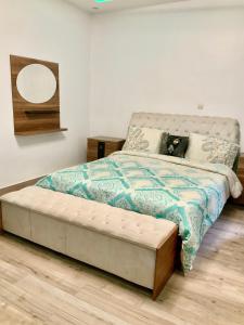 Un dormitorio con una cama con colchón capitoné y un espejo. en Appartement de rêve, en Dakar
