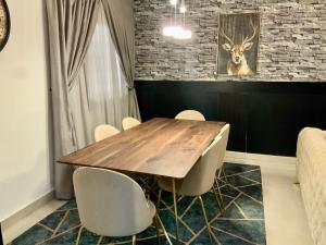 Un comedor con mesa y sillas de madera. en Appartement de rêve, en Dakar