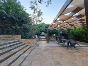 a patio with a table and chairs under a pavilion at Villa Saya Jerash in Jerash