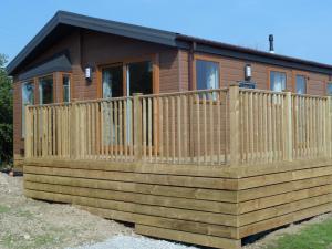 a log cabin with a wooden fence at Clearwater lodge in Perranporth