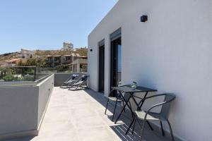 Un patio con sillas y una mesa en un balcón. en Villa Calissea, en Agia Pelagia