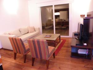 sala de estar con sofá, mesa y sillas en Departamento Cerro Catedral en San Carlos de Bariloche
