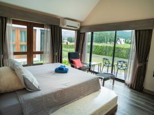 a bedroom with a large bed and a large window at Berghaus101khaoyai in Nakhon Ratchasima