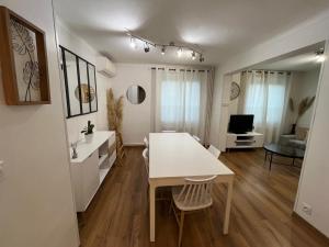 a kitchen and living room with a white table and chairs at La Maison Mirabelle in Chilly-Mazarin