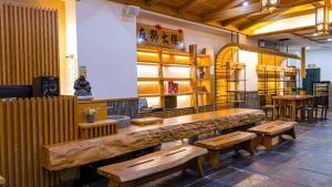 un ristorante con tavoli e panche in legno in una stanza di Dragon Manor Resort a Ren'ai