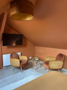 a living room with two chairs and a table at Parenthèse sous les toits - suite cosy avec jacuzzi - hypercentre in Auxerre