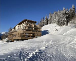 ein Gebäude auf einer schneebedeckten Skipiste in der Unterkunft ARC 1600, LE RIDGE, Appartement 10 personnes Vue Montagne - ski aux pieds - Sauna, Hammam, Piscine in Arc 1600
