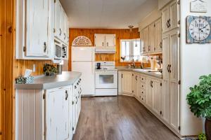 a kitchen with white appliances and wooden cabinets at Lake Nature & Outdoor Fun - Chalet Mandeville II in Mandeville