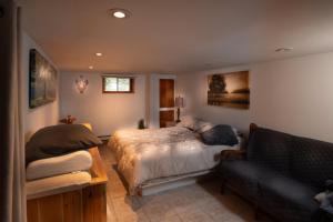 a bedroom with a bed and a couch at Lake Nature & Outdoor Fun - Chalet Mandeville II in Mandeville +7 photos