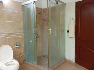 a bathroom with a glass shower with a toilet at CHK INN by ChenOne in Lahore