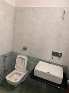 a bathroom with a toilet and a sink at Shikhar Bunglow - A Stunning Valley View Bunglow in Mount Abu in Mount Ābu