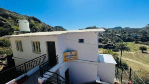 a small white building with a sign on it at Shikhar Bunglow - A Stunning Valley View Bunglow in Mount Abu in Mount Ābu