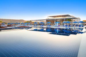 马萨阿拉姆Pickalbatros Villaggio Aqua Park - Portofino Marsa Alam的度假村的游泳池,配有蓝色遮阳伞