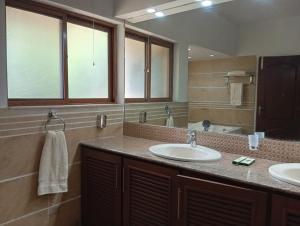 a bathroom with two sinks and a large mirror at CHK INN by ChenOne in Lahore