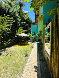 a walkway next to a building with an umbrella at Pousada Amor de Casa in Trancoso +64 photos